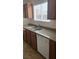 This kitchen features a stainless steel sink, granite countertops, wood cabinets, and a white dishwasher at 1858 N Decatur Blvd # 204, Las Vegas, NV 89108
