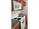 The kitchen features a white microwave and a white range oven, with wood cabinets and granite countertops at 1858 N Decatur Blvd # 204, Las Vegas, NV 89108