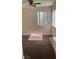 Living room area featuring carpet flooring and a ceiling fan, with window view at 1858 N Decatur Blvd # 204, Las Vegas, NV 89108