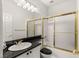 Bathroom featuring a combination shower and tub with a gold frame, tile, and black countertop at 2037 Summer Blossom Ct # 101, Las Vegas, NV 89134