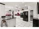 Well lit eat-in kitchen boasts white cabinets, black appliances, red backsplash, and tile floors at 2037 Summer Blossom Ct # 101, Las Vegas, NV 89134