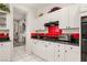 White kitchen with red tile accents, black countertops, and ample cabinet space at 2037 Summer Blossom Ct # 101, Las Vegas, NV 89134