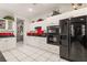 Bright kitchen boasts white cabinets, black appliances, and red backsplash adding a pop of color at 2037 Summer Blossom Ct # 101, Las Vegas, NV 89134