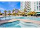 Daytime view of the luxurious pool and spa area, surrounded by palm trees and lush landscaping at 222 Karen Ave # 2401, Las Vegas, NV 89109