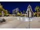 Scenic view of a relaxing pool area at night with rock features, palm trees and comfortable lounge chairs at 222 Karen Ave # 2401, Las Vegas, NV 89109