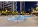 Nighttime view of a resort-style pool surrounded by palm trees, rocks and landscape lighting at 222 Karen Ave # 2401, Las Vegas, NV 89109