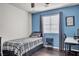 Comfortable bedroom with a well-lit window, desk space, and a gray plaid bedspread at 235 Desert Arroyo Ct, Henderson, NV 89012