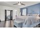 A primary bedroom with a king size bed, wood floors, accent wall, and ceiling fan at 235 Desert Arroyo Ct, Henderson, NV 89012