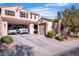 Charming home exterior with a two-car garage, a one-car garage, and a spacious driveway with multiple vehicles at 235 Desert Arroyo Ct, Henderson, NV 89012