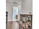 Bright hallway leading to a bathroom featuring a dark-stained wood bookshelf and beautiful flooring at 235 Desert Arroyo Ct, Henderson, NV 89012
