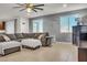 A sectional sofa sits in a cozy living room featuring gray walls, tile floors, and large windows at 235 Desert Arroyo Ct, Henderson, NV 89012