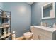 Powder room with blue walls, white vanity, and modern fixtures at 2422 Fasano St, Henderson, NV 89044