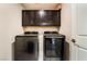 Laundry room featuring dark brown cabinets over modern washer and dryer units at 2422 Fasano St, Henderson, NV 89044
