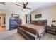 Spacious bedroom with a wooden bed frame, a ceiling fan, and natural lighting at 2422 Fasano St, Henderson, NV 89044