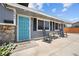 Inviting front porch with a vibrant blue door, seating, and landscaped entryway at 2447 Tournament St, Las Vegas, NV 89142