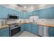 Close up of kitchen with butcher block countertops, stainless steel appliances, and blue cabinets at 2447 Tournament St, Las Vegas, NV 89142