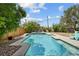 Inviting backyard featuring a private pool with spa, bordered by lush greenery and a wooden fence at 2447 Tournament St, Las Vegas, NV 89142