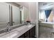 Bathroom with double sinks, granite countertops, framed mirror and doorway to the Primary bedroom at 2719 Canvas Sky St, Henderson, NV 89044