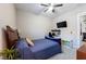 Cozy bedroom with a ceiling fan, TV, work station, and a blue bedspread at 2719 Canvas Sky St, Henderson, NV 89044