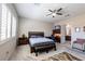 Bedroom with ceiling fan, a desk, large bed, an ensuite bathroom and a window with shutters at 2719 Canvas Sky St, Henderson, NV 89044