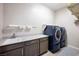 Laundry room complete with front-load washer/dryer and a utility sink at 2719 Canvas Sky St, Henderson, NV 89044
