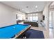 Open-concept living room featuring a billiard table, ample natural light, and stylish decor at 2719 Canvas Sky St, Henderson, NV 89044