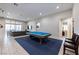 Spacious living room with a pool table, comfortable seating, and seamless access to the outdoors at 2719 Canvas Sky St, Henderson, NV 89044