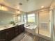 Bathroom featuring a double sink vanity, soaking tub, and glass-enclosed shower for a spa-like experience at 2922 Tranquil Brook Ave, Henderson, NV 89044