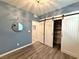 Cozy bedroom with blue walls, wood floors, and a barn door leading to the closet at 2922 Tranquil Brook Ave, Henderson, NV 89044