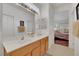 Bright bathroom with double sinks, neutral tile floors and a large mirror at 2969 Sumter Valley Cir, Henderson, NV 89052