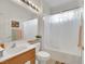 Well-lit bathroom with shower-tub combo, wood vanity, white toilet, and neutral paint at 2969 Sumter Valley Cir, Henderson, NV 89052