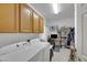 Well-organized laundry room with washer, dryer, storage cabinets, and a desk at 2969 Sumter Valley Cir, Henderson, NV 89052