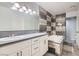 Bright bathroom featuring a double vanity, decorative mirrors, and a separate tub with stylish gray-toned tile surround at 3609 Laguna Del Sol Dr, Las Vegas, NV 89121