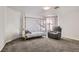Cozy bedroom with neutral gray carpet and a modern canopy bed and a comfortable reclining chair at 3609 Laguna Del Sol Dr, Las Vegas, NV 89121