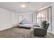 Comfortable bedroom with neutral gray carpet, bright lighting, a modern canopy bed and a comfy reclining chair at 3609 Laguna Del Sol Dr, Las Vegas, NV 89121