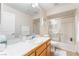 Well-lit bathroom featuring a vanity, large mirror, toilet, and glass-enclosed shower-tub combination at 4097 Nook Way # A, Las Vegas, NV 89103