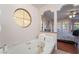 Spa-like bathroom featuring a jacuzzi tub, arched windows, and access to main bedroom at 4097 Nook Way # A, Las Vegas, NV 89103