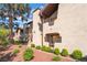 Exterior shot of a charming condo with a tile roof, red rock landscaping, and lush green shrubbery at 4097 Nook Way # A, Las Vegas, NV 89103