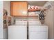Functional laundry area with side by side washer and dryer, storage cabinets, and shelving at 4097 Nook Way # A, Las Vegas, NV 89103
