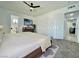 Staged bedroom features neutral tones, a ceiling fan, and an ensuite bathroom at 4324 El Conlon Ave, Las Vegas, NV 89102
