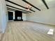 Spacious living room featuring black ceiling beams, a fireplace, and vinyl floors at 4324 El Conlon Ave, Las Vegas, NV 89102