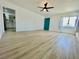 Spacious living room with vinyl floors, a window, and a bright teal door at 4324 El Conlon Ave, Las Vegas, NV 89102