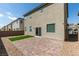 Home backyard features a brick patio, gravel ground cover and partial views of neighborhood homes at 4642 Chirping St, North Las Vegas, NV 89031