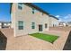 Backyard featuring artificial grass, patio, gravel, and surrounding brick fence for privacy at 4642 Chirping St, North Las Vegas, NV 89031