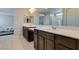 Bathroom showcasing double sinks, dark wood cabinets, with a mirror reflecting the bedroom at 4642 Chirping St, North Las Vegas, NV 89031