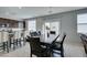 View of the dining area with bar seating and dark wood table near the sliding glass doors at 4642 Chirping St, North Las Vegas, NV 89031