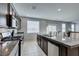 Open kitchen with stainless steel appliances, granite countertops, and a large island with barstool seating at 4642 Chirping St, North Las Vegas, NV 89031