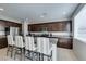 Bright kitchen with granite counters, stainless appliances, an island with seating and tile floors at 4642 Chirping St, North Las Vegas, NV 89031