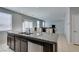 Open-concept kitchen with stainless steel appliances, granite counters, large island, and tile flooring at 4642 Chirping St, North Las Vegas, NV 89031