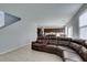 Open-concept living room with a large brown leather sectional, and connecting dining area at 4642 Chirping St, North Las Vegas, NV 89031